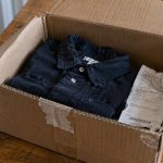 A folded shirt and receipt inside an open return box.
